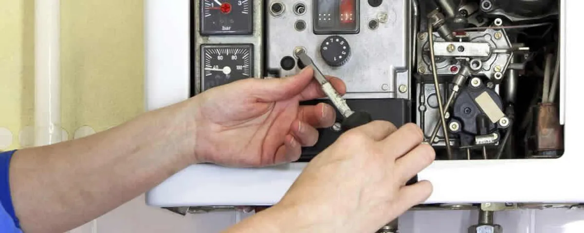 Heating repair technician adjusting boiler controls and components in Royal Oak, MI